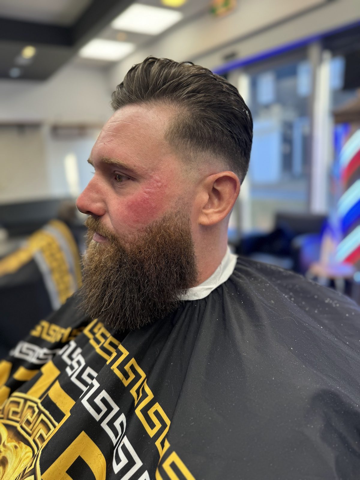 Volle baard in model gebracht, met een quiff bovenop