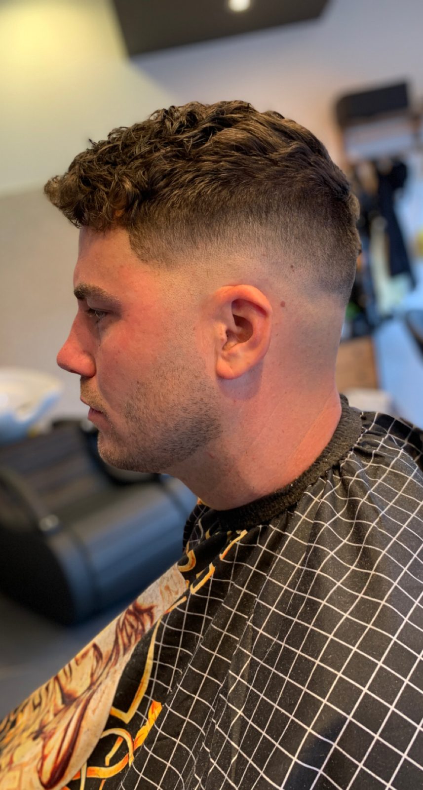 Krullen met een huidfade, bij daglicht in de zaak